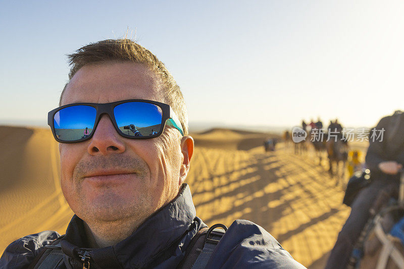 摩洛哥撒哈拉沙漠的梅尔祖加，Erg Chebbi，游客在沙漠中骑骆驼
